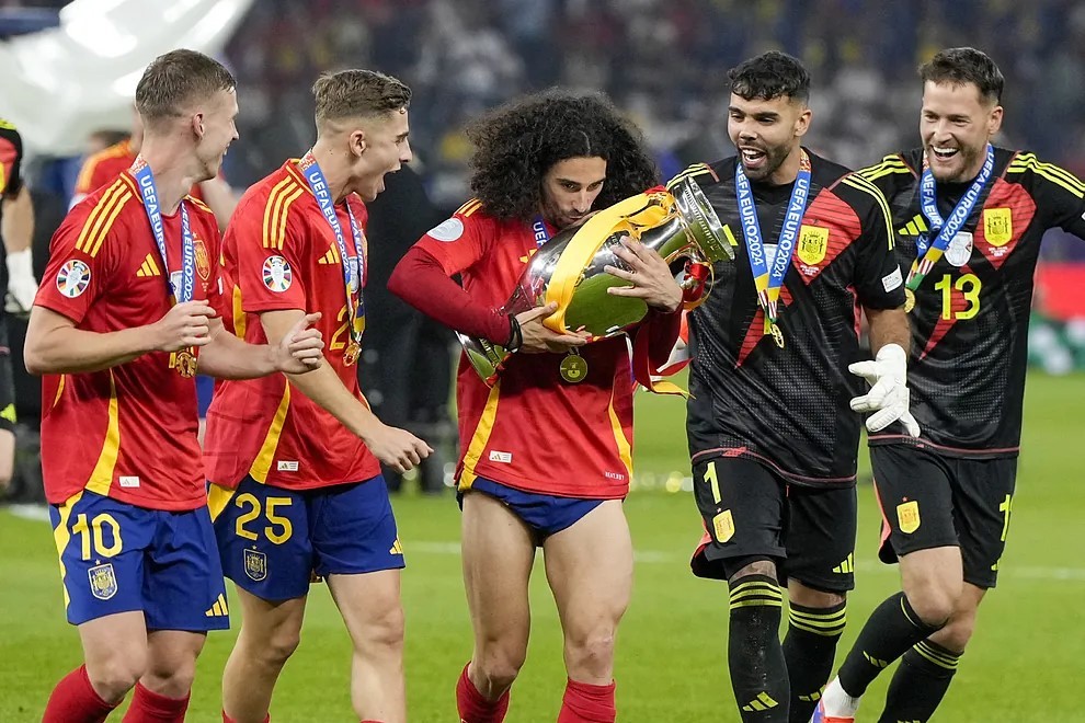 Marc Cucurella sujetando el t�tulo de la Eurocopa rodeado de varios de sus compa�eros