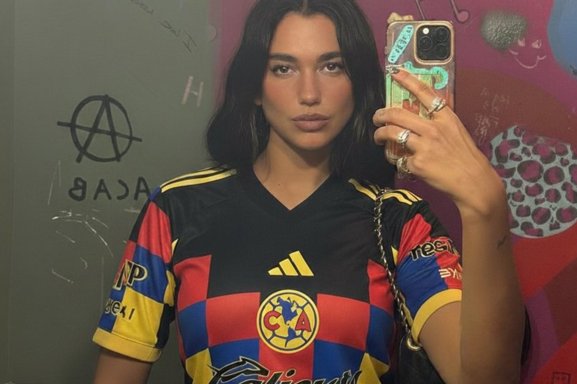 En la imagen, la compositora aparece tomándose una foto frente al espejo con la del América.