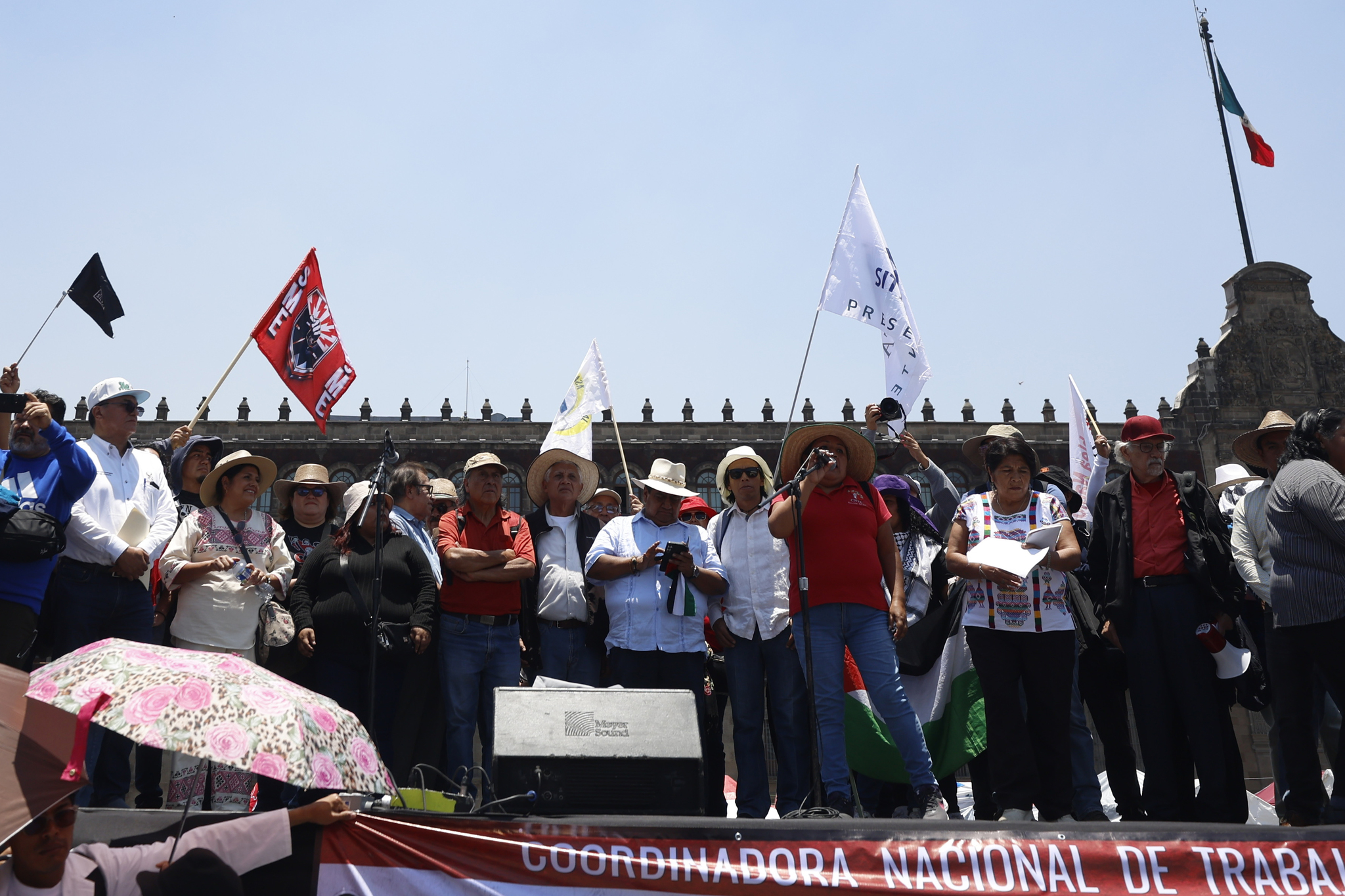 Personas sostienen banderas durante la conmemoraci�n del D�a del Maestro en Ciudad de M�xico
